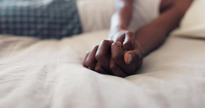 Closeup, bed and couple with love, holding hands and trust with support, marriage and relationship. Home, people and hope with bonding, peace and weekend break with happiness, bedroom and commitment