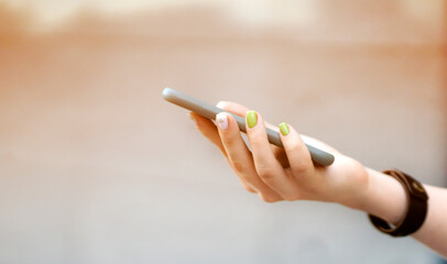 Girl is holding a smartphone in her hands closeup view.