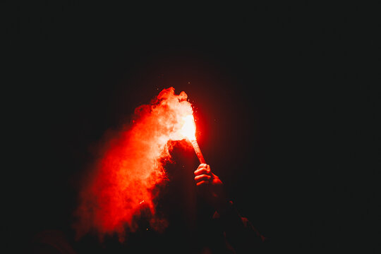 Football fan holding red flare during football match in Brazil.  It is a tradition to welcome Sport Club Internacional to games.