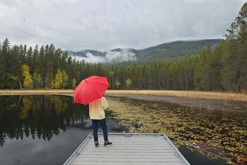 Woman with umbrella on a dock.