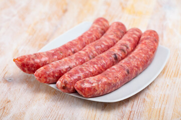 Raw botifarra (or llonganissa) from minced pork on wooden surface. Popular Catalan sort of sausages