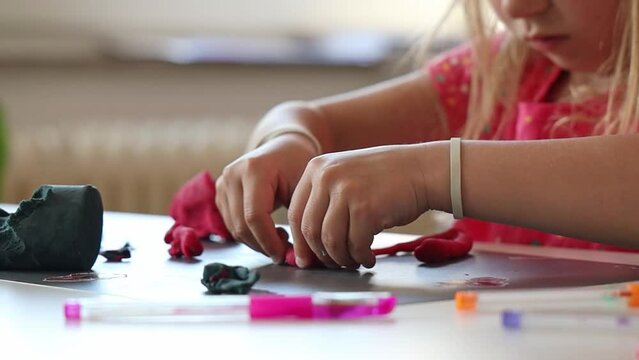 Little girl sculpts with play dough.