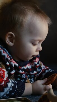 Christmas concept. Vertical video portrait of toddler boy wearing Christmas sweater at home.