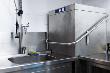 Industrial dishwasher in a restaurant kitchen washing dishes