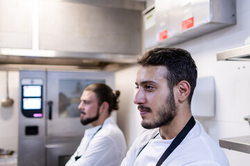 Naklejka na ściany i meble Portrait of an arabe chef with his partner with long hair at the background