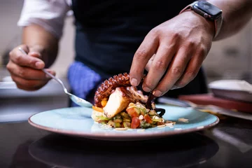 Zelfklevend Fotobehang Hands finishing plating the octopus for restaurant customers © Martin