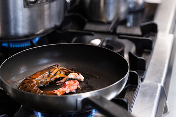 Photo of a pan with half lobster inside it to then prepare a pasta dish