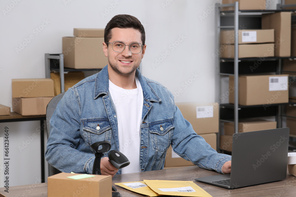 Poster Seller with scanner, parcels and laptop at table in office. Online store