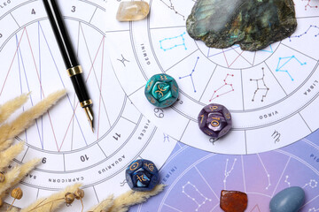 Zodiac wheels, natal chart, fountain pen, astrology dices and gemstones, flat lay