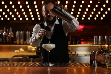 Bartender making fresh alcoholic cocktail at bar counter, selective focus