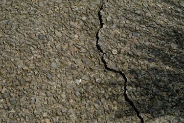 the asphalt surface is rocky with small cracked pebbles. gray.