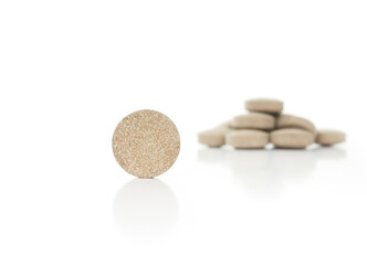 Round wafer tablet with defocused pile. Multiple green textured pressed tablets or pills. Isolated...