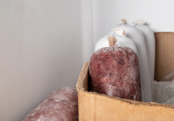 Raw food sausages for dogs in freezer. Raw meat diet or barf for dogs, cats and pets. Organic human grade ground chicken and beef with muscle, bone and organs. Selective focus.