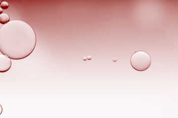 Abstract rose pink on serum oil bubbles on surface textures background.  Macro photography on an...