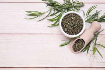 Dry and fresh tarragon on wooden table, flat lay. Space for text
