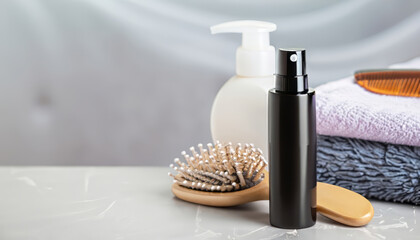 Dry shampoo spray, towels, hair brush on light grey surface, blurry background - obrazy, fototapety, plakaty