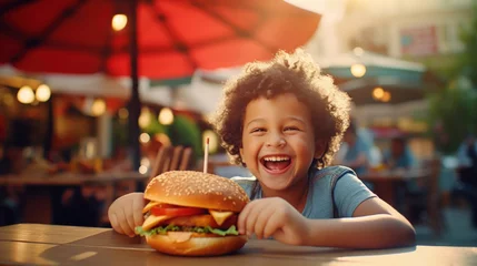 Rolgordijnen Happy kid in a street cafe with burger © tashechka