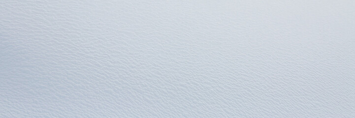 Natural snow texture. Smooth surface of clean fresh snow. Snowy ground. Winter background with snow patterns. Closeup top view. Wide panoramic texture for background and design.