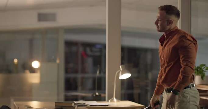 Baseball bat, computer and smash with a business man in his office at night for deadline stress or pressure. Anger, frustration and burnout with a young employee breaking his desktop in the workplace