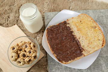 Bread with chocolate spread filling, milk and snack for breakfast