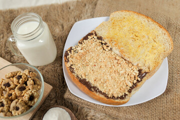 Bread with peanut, chocolate and butter spread on a table for breakfast