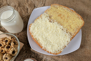 Bread with cheese, sweetened condensed milk, and butter. With white milk and snack on a table for breakfast