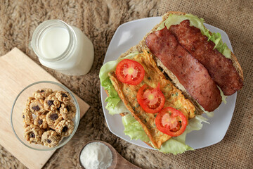 Big breakfast, bread, chicken slice, tomato, lettuce, smoked beef, egg, salad with milk. Bread sandwich fresh and healthy food meal lunch dinner breakfast slices of sandwiches.