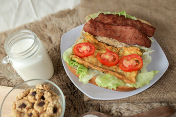 Big breakfast, bread, chicken slice, tomato, lettuce, smoked beef, egg, salad with milk. Bread sandwich fresh and healthy food meal lunch dinner breakfast slices of sandwiches.