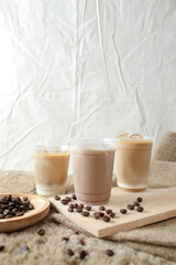 Delicious iced coffee, mocca, and chocolate drinks with coffee beans on white wooden table