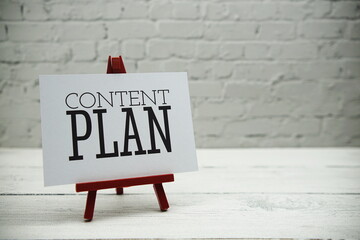Content Plan text on white brick wall and wooden background