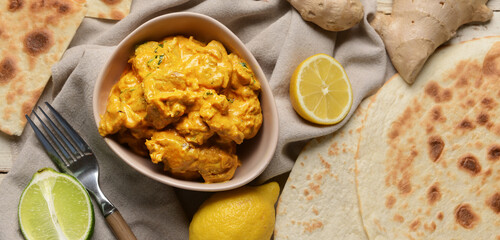 Bowl of tasty chicken tikka masala on table