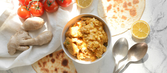 Bowl of tasty chicken tikka masala on white table