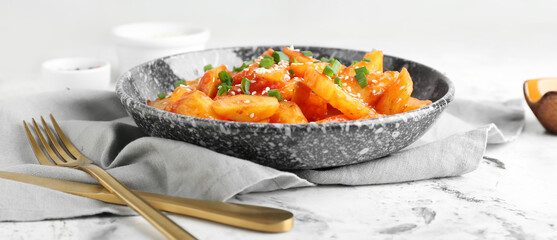 Plate with honey chilli potato on grunge background