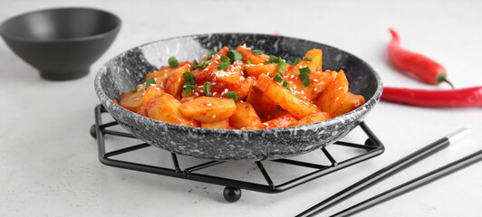 Plate with honey chilli potato on white table