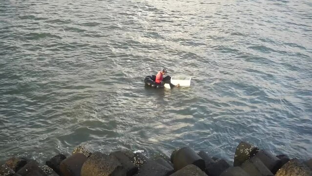A fisherman is fishing using a traditional boat.