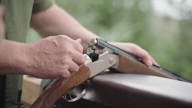 Chambering ammo into a shot gun ready to fire. Shooting clay pigeons.