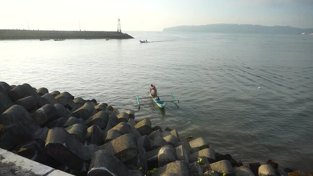 A fisherman is fishing using a traditional boat.