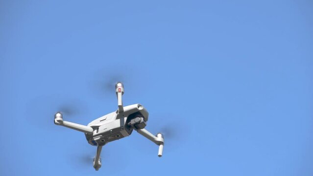 Drone equipped with camera flying under blue sky in background