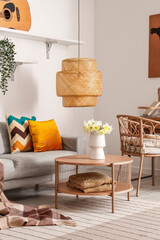 Vase with beautiful narcissus flowers on coffee table in interior of stylish living room