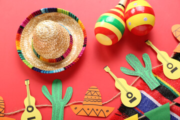 Mexican maracas with sombrero hat, paper garland and flags on red background