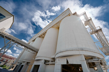 Huge concrete silos for lime storage against cloudy sky