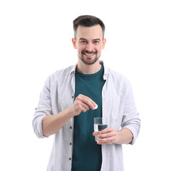 Young man with soluble tablet and glass of water on white background