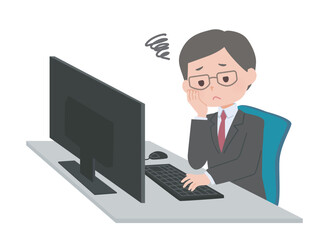 パソコンの前で悩むスーツの男性