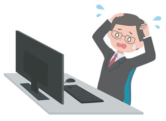 パソコンの前で頭を抱える眼鏡をかけたビジネスマン