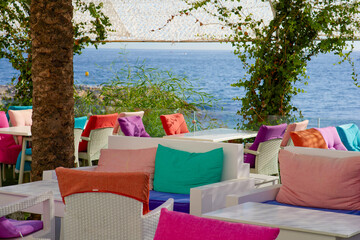 Colorful pillows on the terrace of the restaurant by the sea