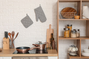 Wooden kitchen counter with cutting boards, electric stove and utensils