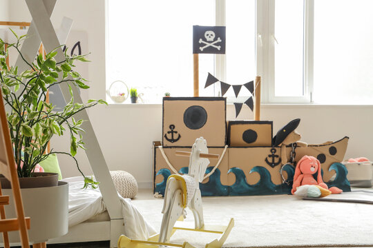 Pirate cardboard ship with toys in children's bedroom