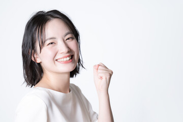 カメラ目線の若い日本人女性のクローズアップ　ガッツポーズ