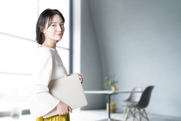 Very easy to use, young woman looking at camera with computer in living room or office Bright image...