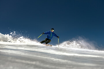 Fast skier rides over ski slope